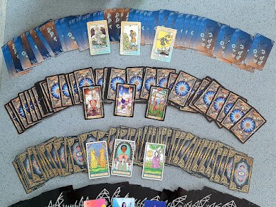 A spread of tarot decks laid out in a fan across a table