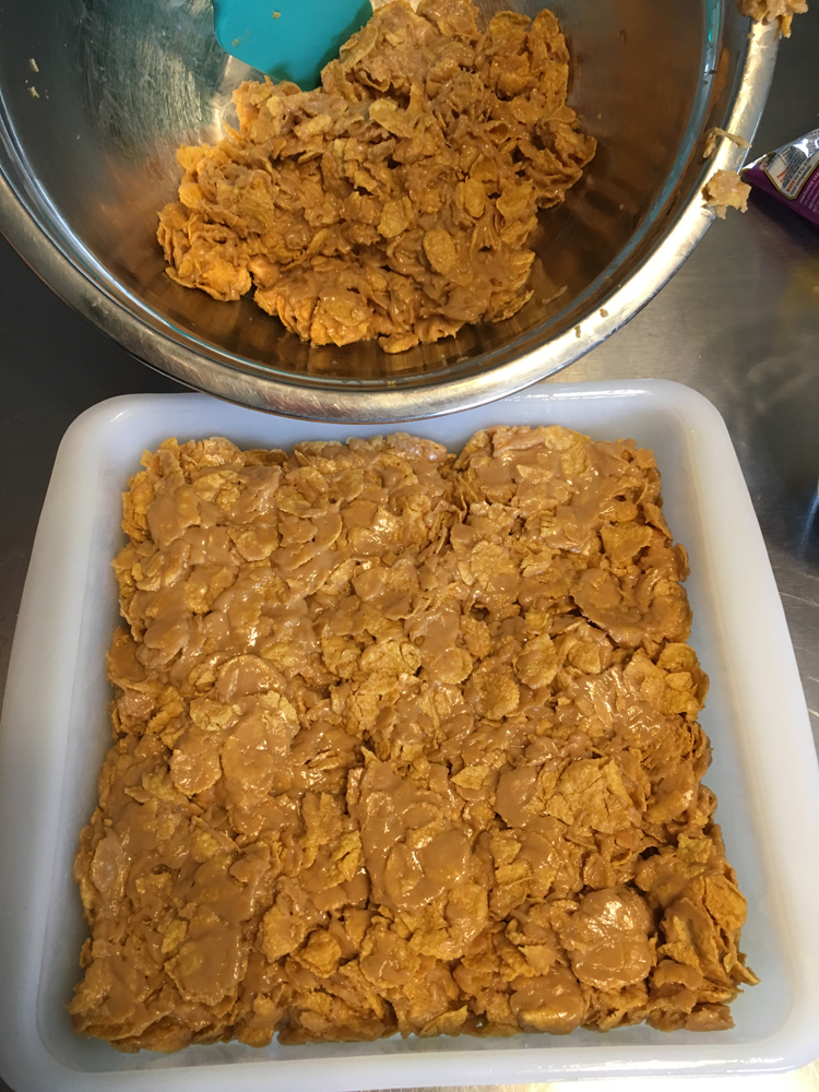 Press the corn flakes into the pan.