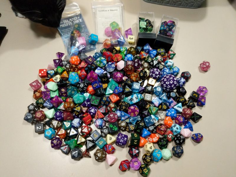 A large pile of polyhedral dice in many colors and sizes.