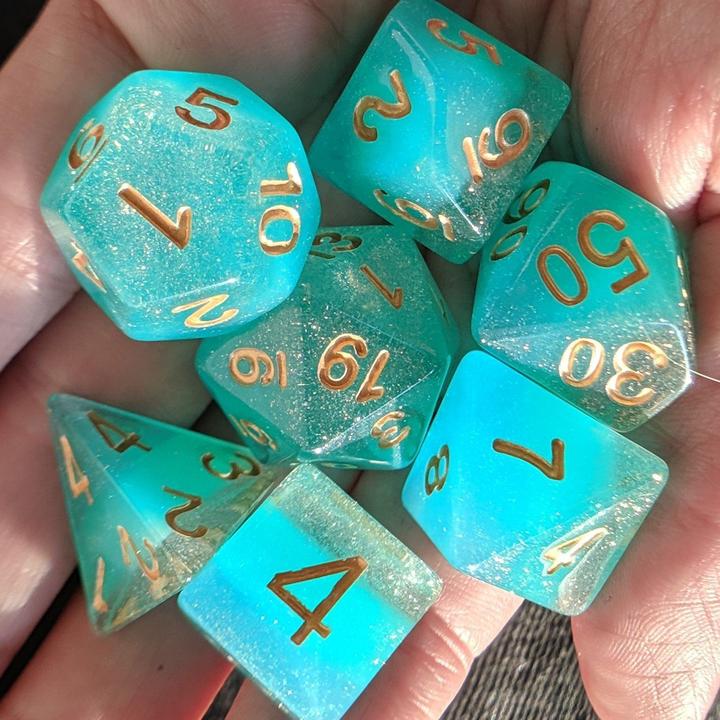 teal gaming dice resting in a hand