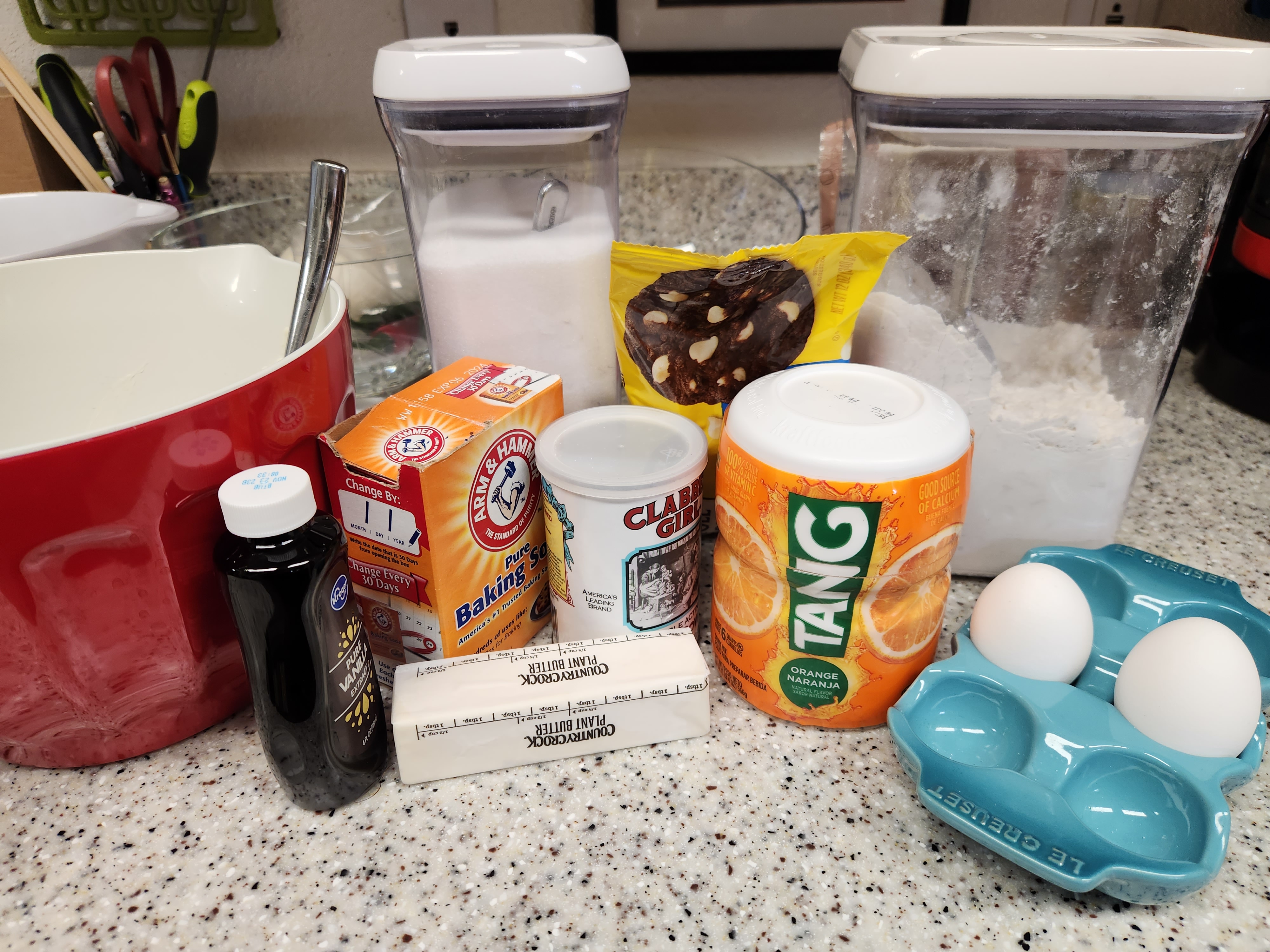 all of the ingredients for the creamsicle cookies sitting on a kitchen counter along with a red and white mixing bowl