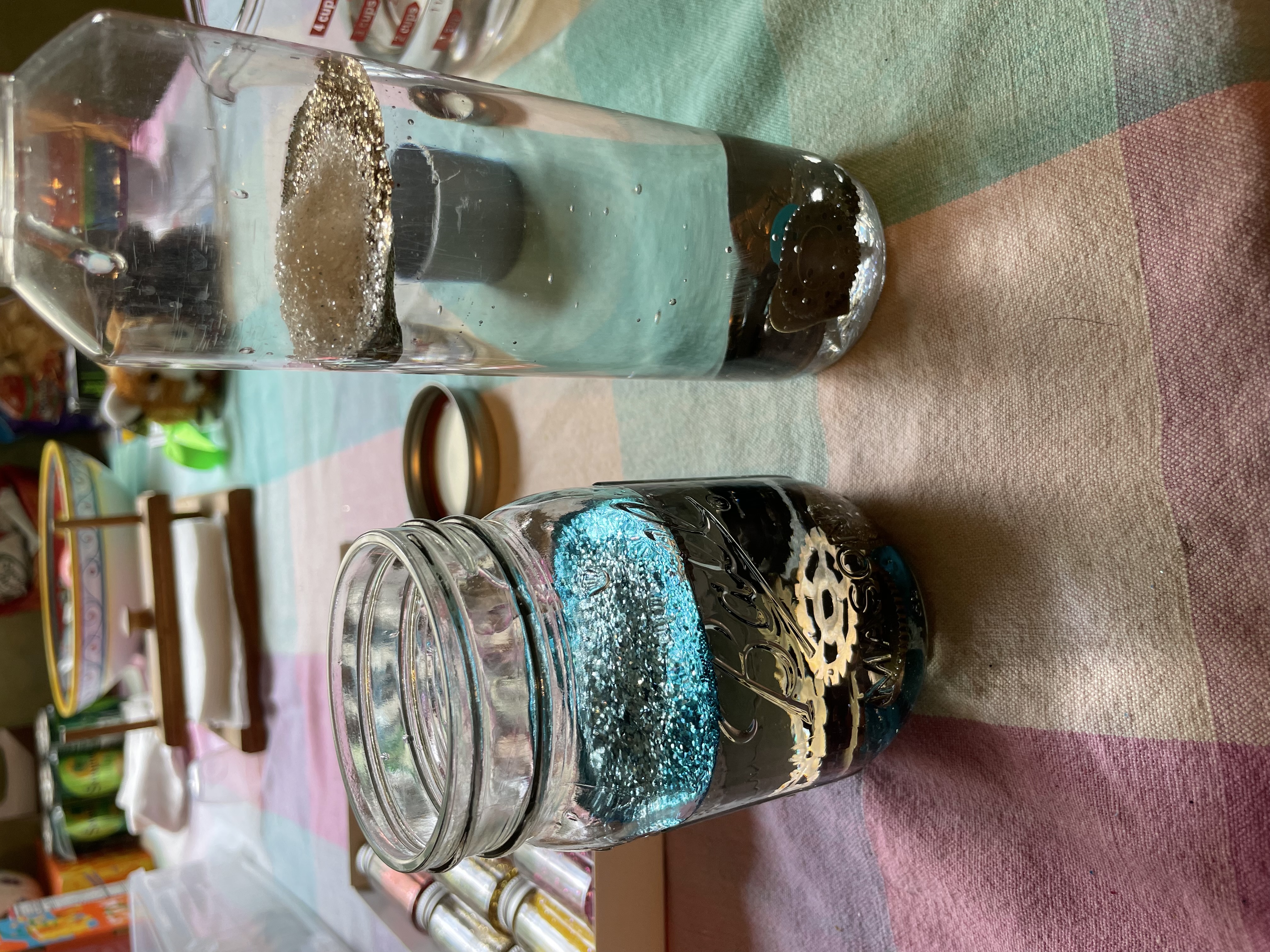 Glitter and other items have been added to two bottles of water and glue