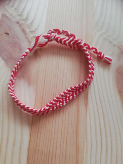 a red and white friendship bracelet with a chevron pattern