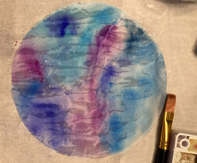 a fully painted coffee filter with blue and purple paint colors