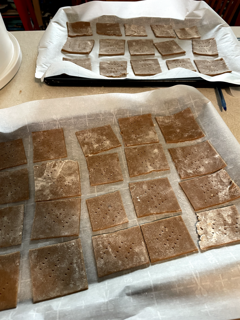 dough has been rolled flat and cut into squares, then laid onto a baking sheet