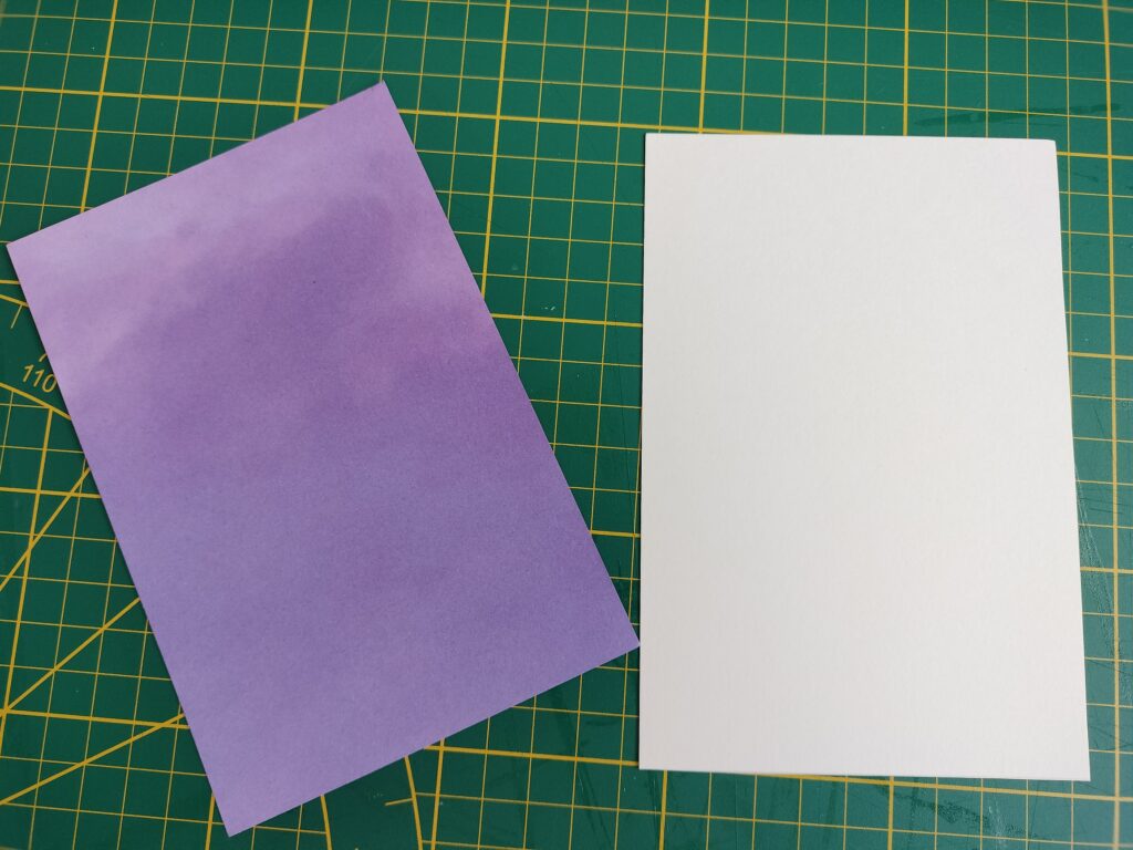 two pieces of cardstock, one is purple and one is white