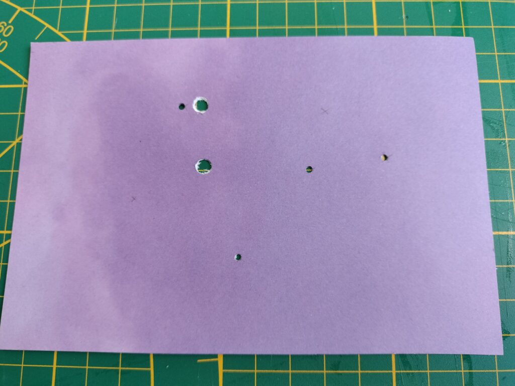 the layered pieces of paper with holes punched through