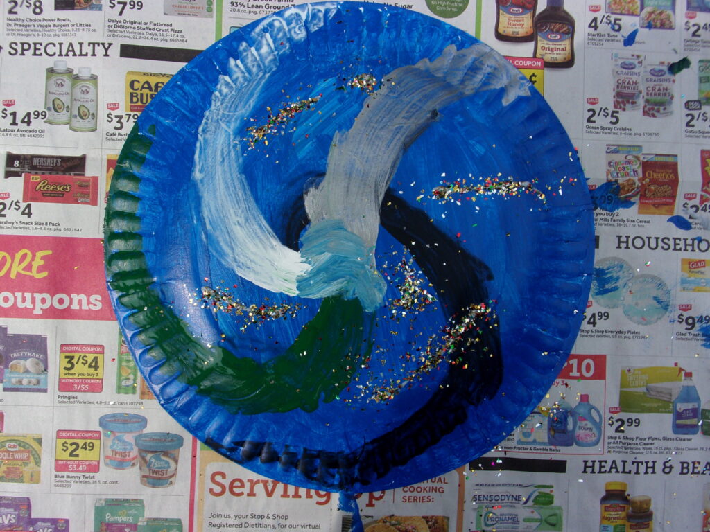 painted paper plate; the main part is blue with silver and green swirls plus glitter