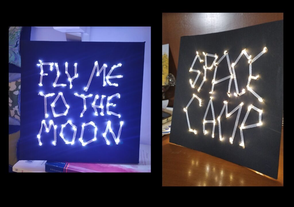 finished product with "fly me too the moon" on dark blue paper and "space camp" on black paper