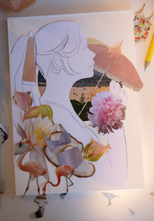 A photo of the collage process with unglued pieces being tweaked around the base paper.