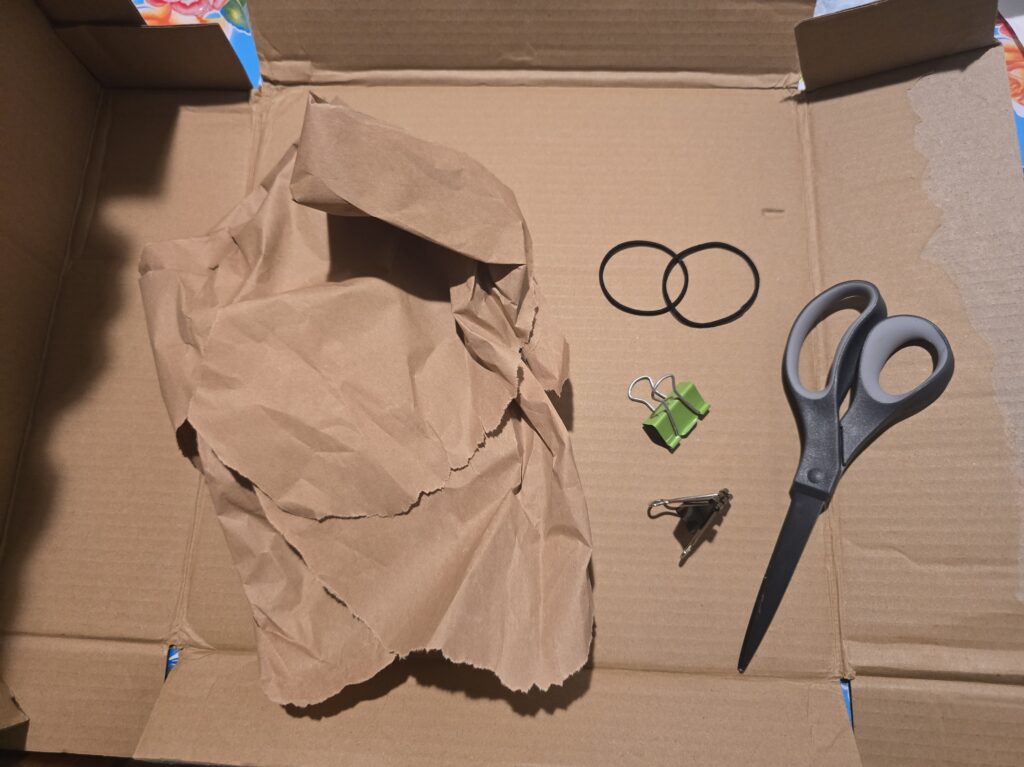 supplies for easy flower press including cardboard, scissors, rubber bands, and brown newspaper