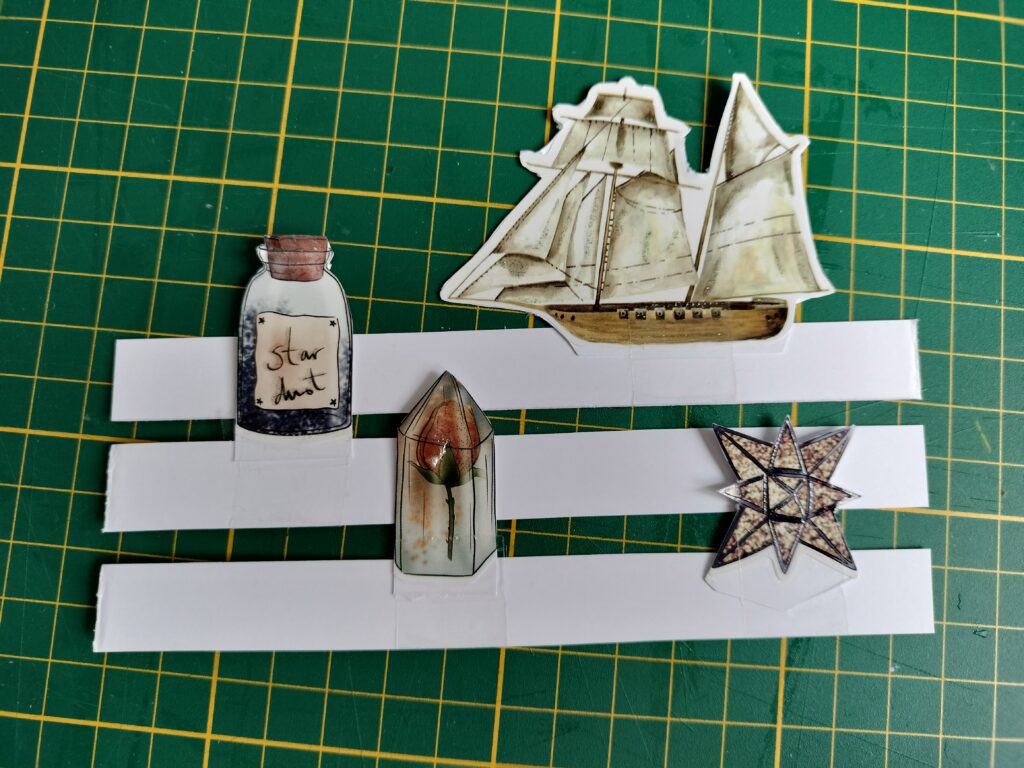 small paper items on another piece of paper, with tabs slid into slots