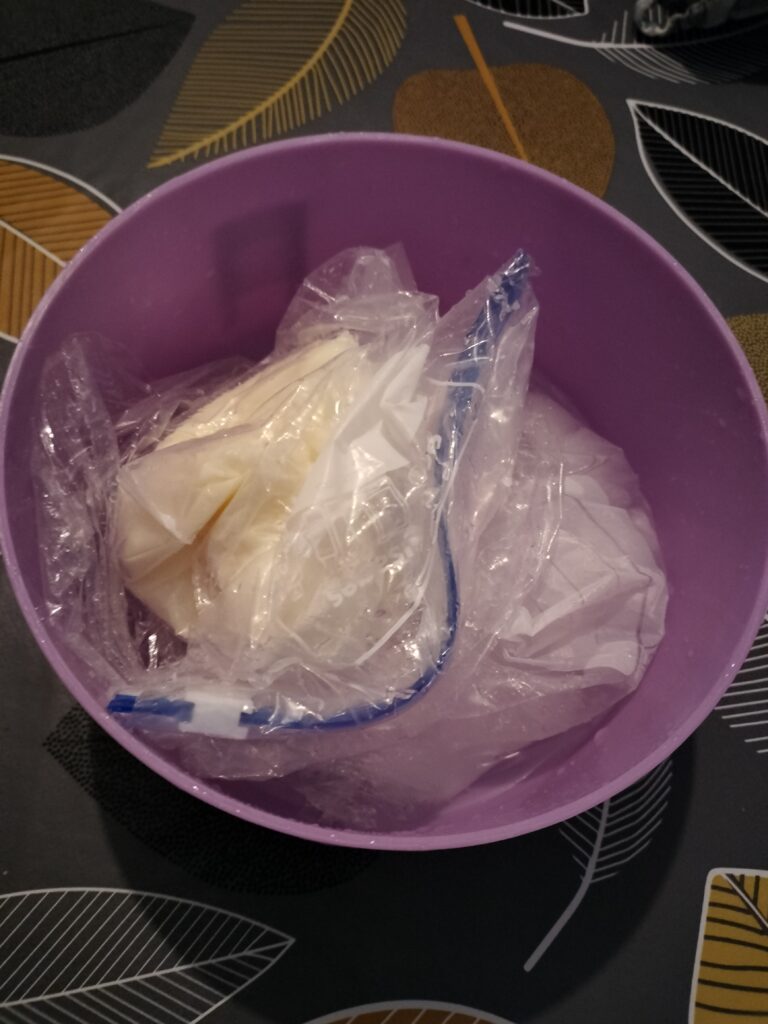 the small bag has been removed from the big bag and the contents appear solid in form -- all now inside a larger bowl