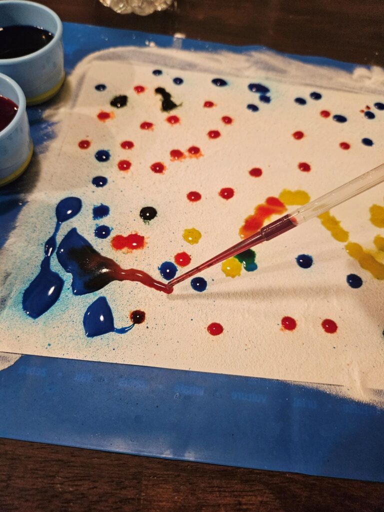 a pipette is visible above the evenly-spread baking soda into little dots